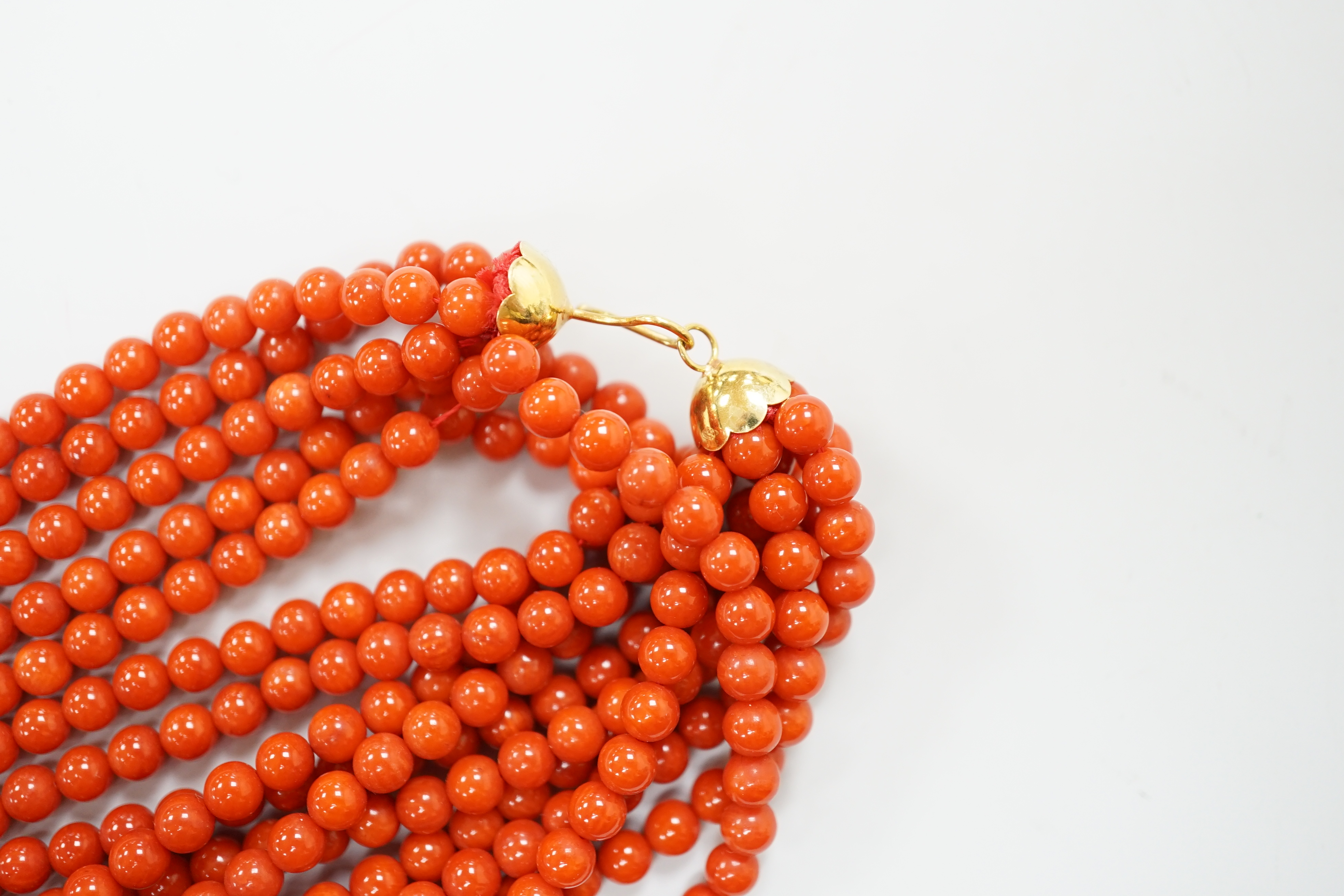 A 1980's Italian multi strand coral bead necklace, with 750 yellow metal clasp and Certificate of Authenticity, 50cm.
